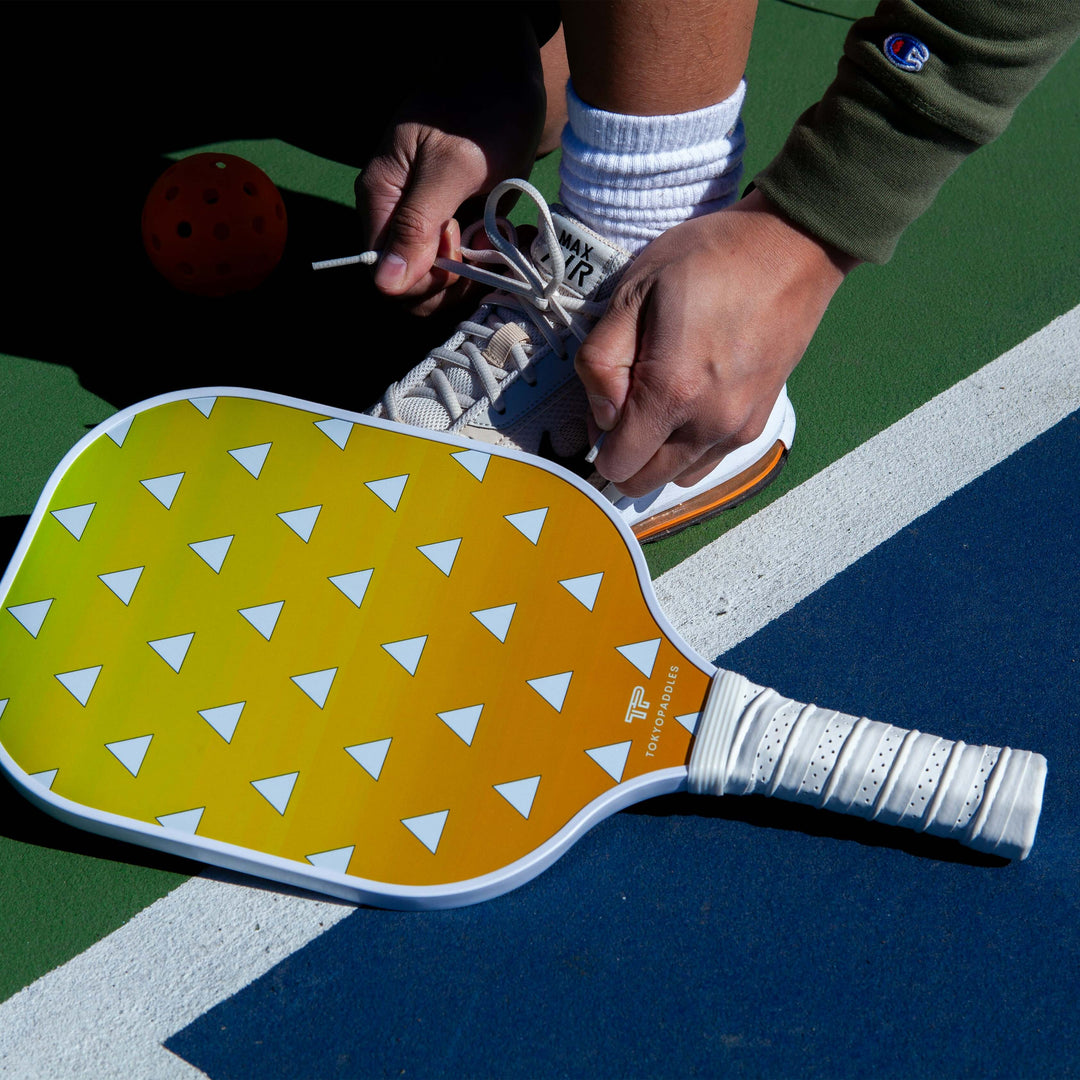 Display a variety of top-notch pickleball paddles authorized by USAPA in 2024. Each paddle should show unique design elements, distinguishing colors and materials. Indicate the chronological order of 