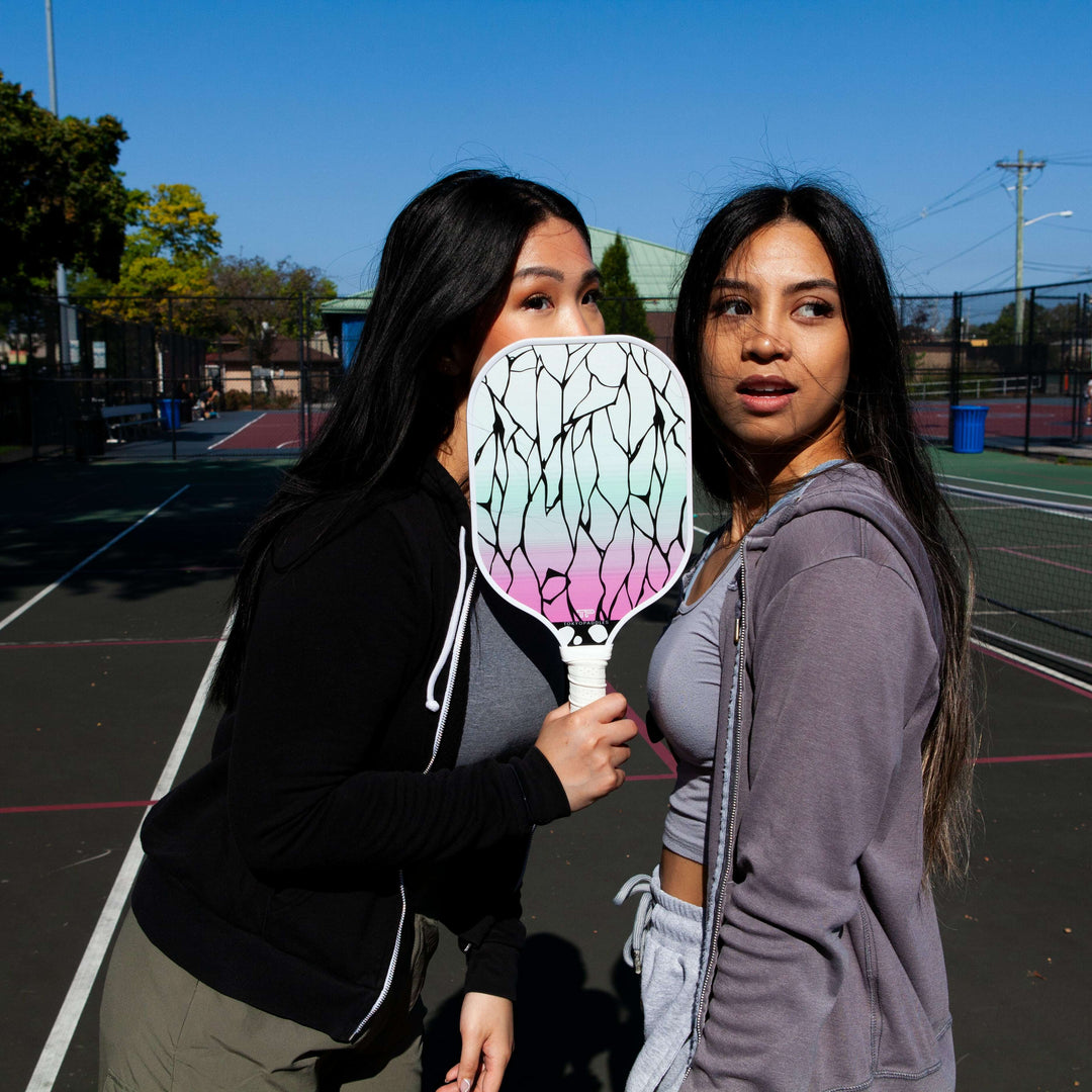 A selection of top-rated pickleball paddles that are all reasonably priced under $100. They feature various design aspects including lightweight materials, ergonomic handles, and colorful patterns. Th